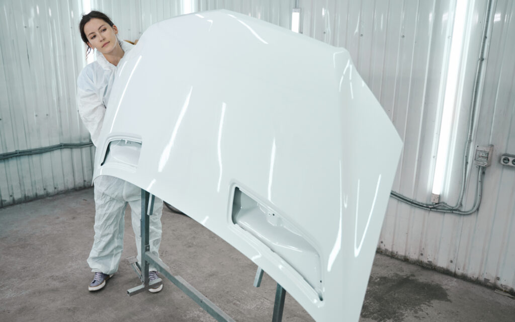 Experto manipulando fibra de vidrio en autopartes.